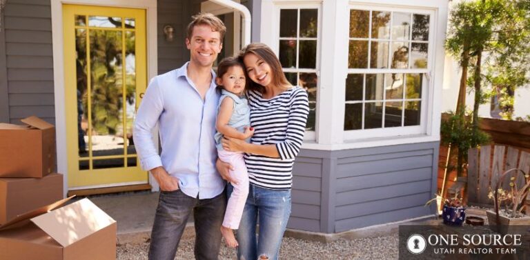 A man and woman holding a child in front of a house.