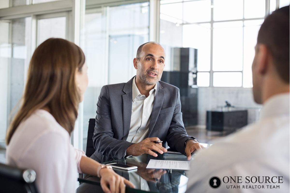 Business meeting with three people discussing.